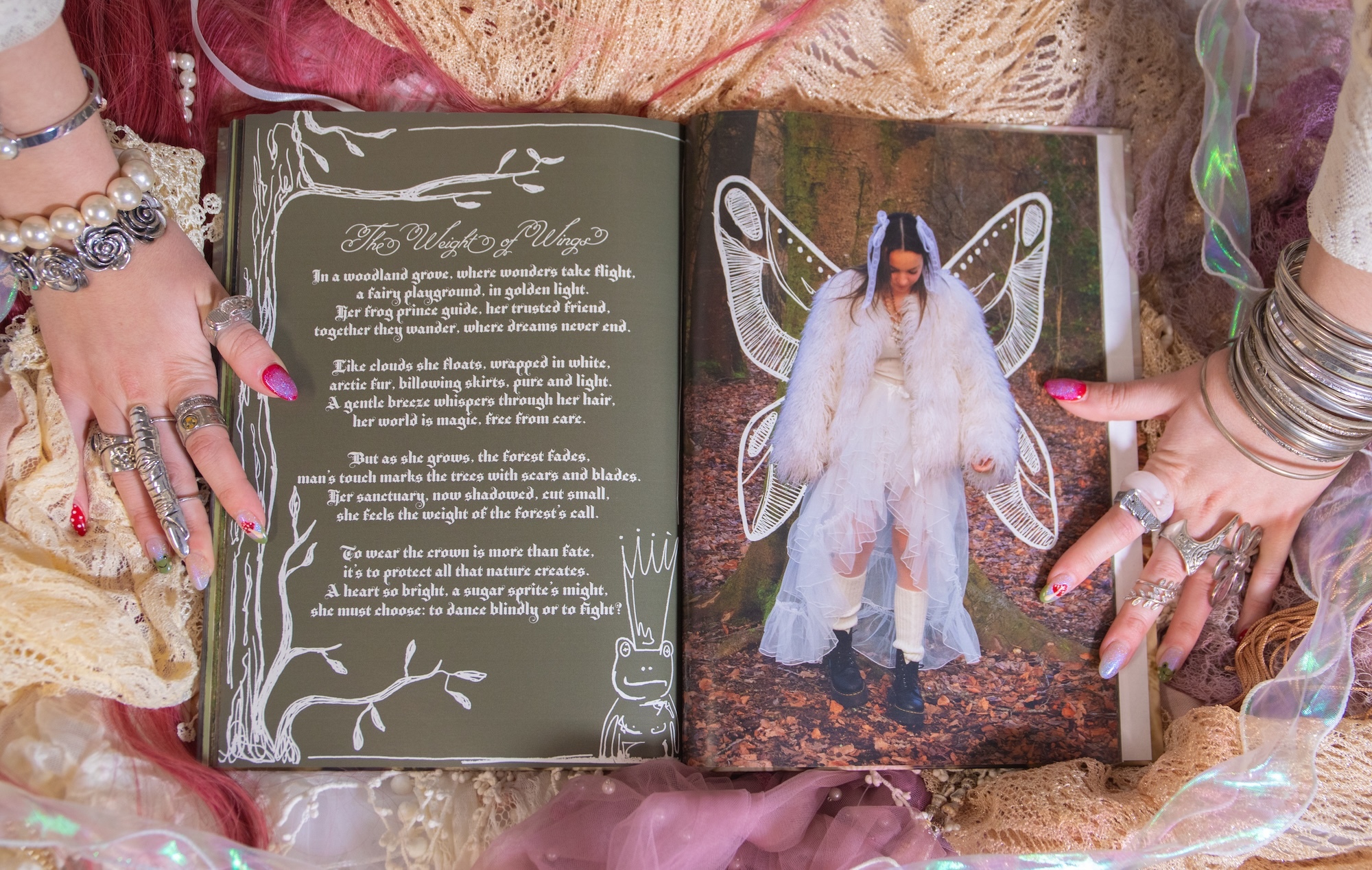 Open book with olive green page containing white text and decorative border, opposite page shows figure in white dress with translucent wings.