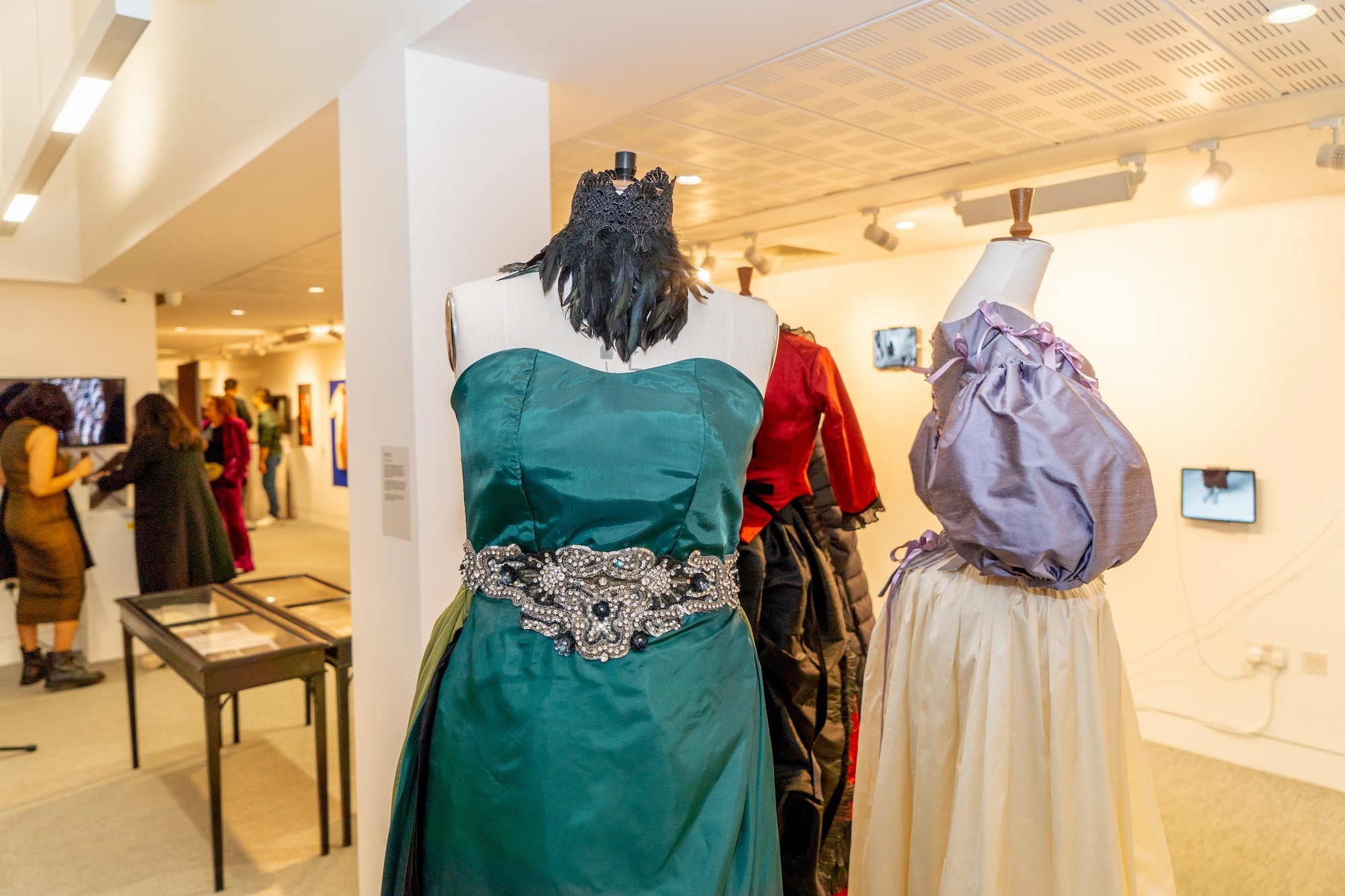 Three historical-style costumes on display on mannequins at TheGallery, Arts University Bournemouth during the 2024 Postgraduate Winter Show.