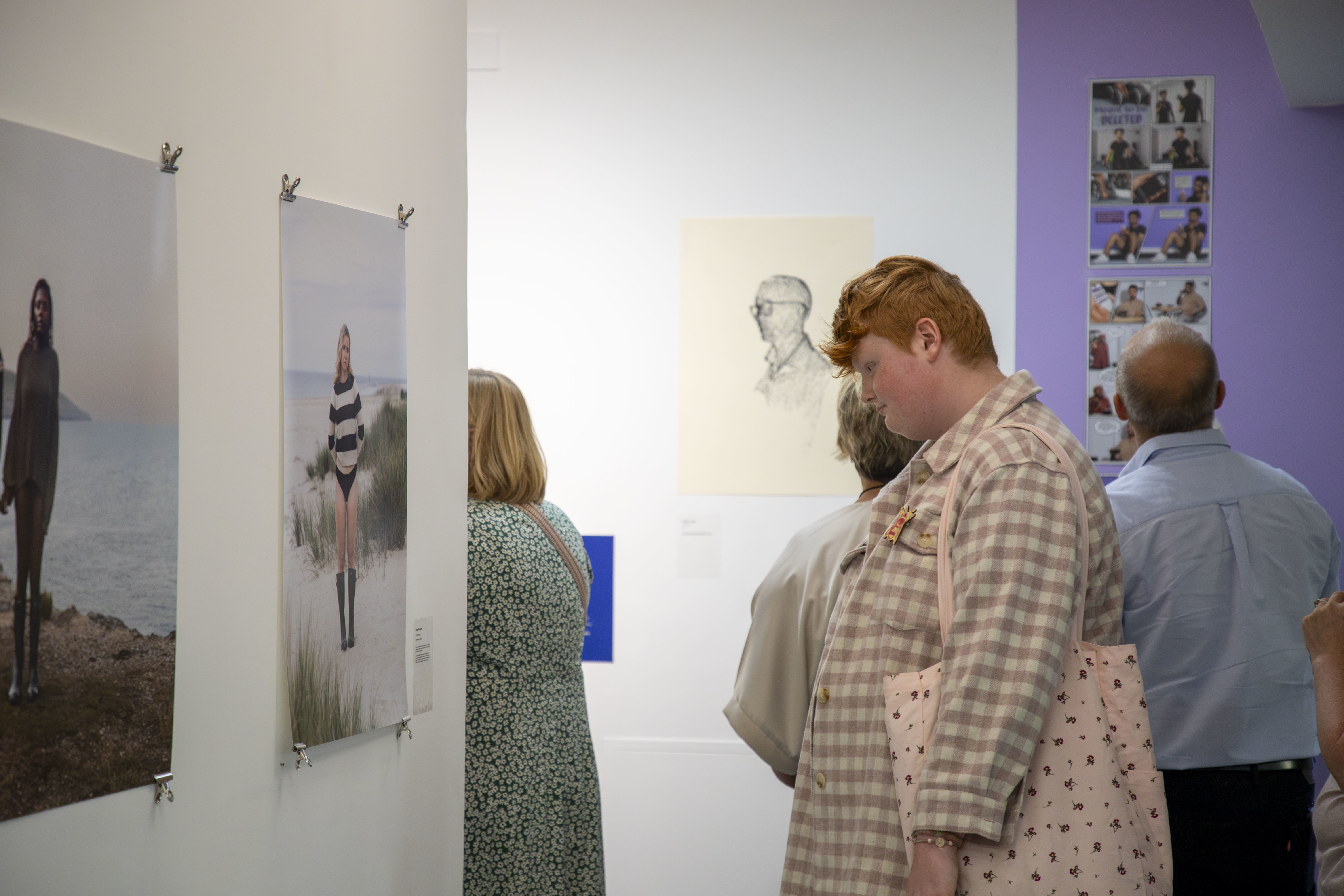 A visitor looking at two large photographs on display at TheGallery, AUB Campus, during the Postgraduate Summer Shows.