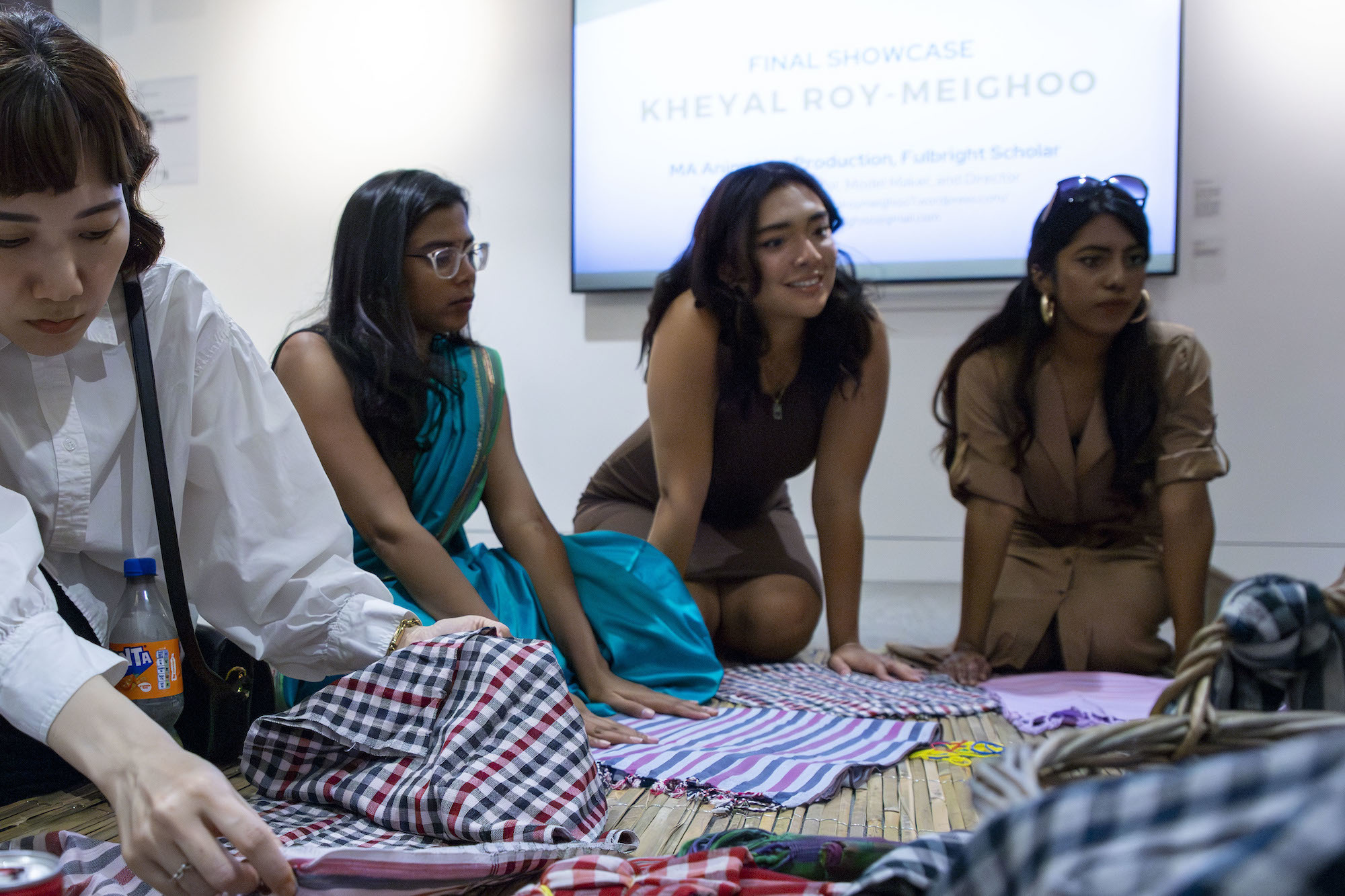 Four people taking part in a project with fabric samples, as part of the Postgraduate Summer Shows on AUB Campus.