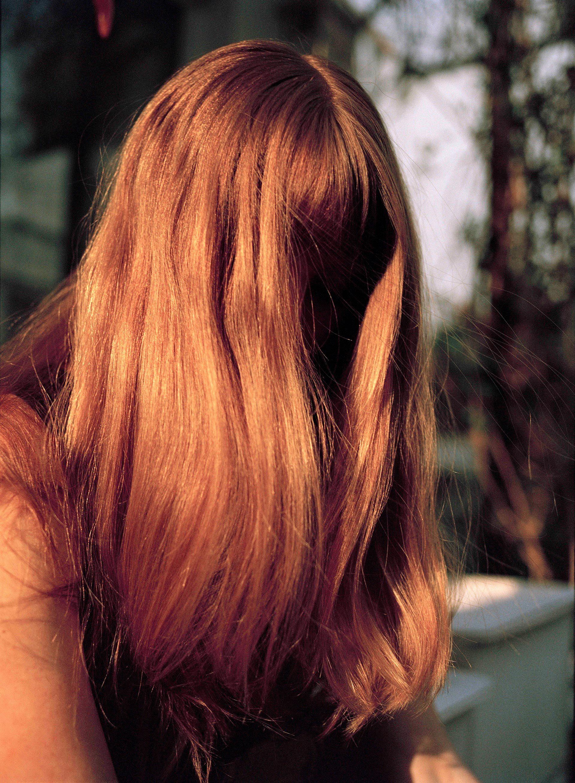 Close-up portrait photograph of a person with hair over their face.
