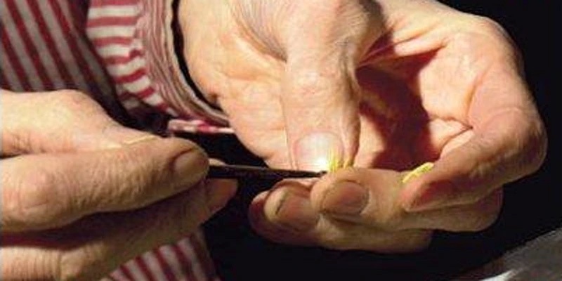 Close-up of a person's hands using a sharp tool.