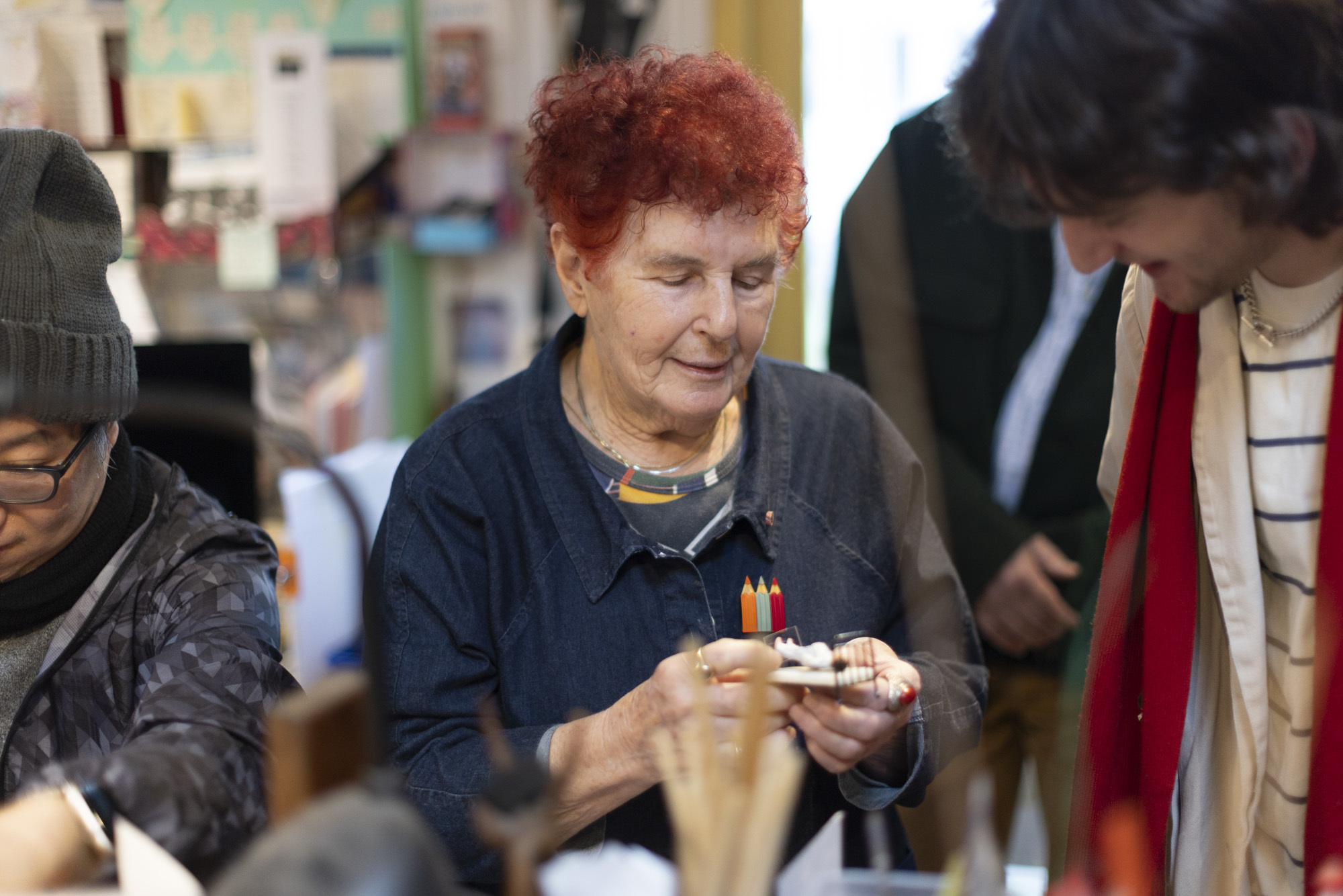 Pamela Howard showing a small miniature piece to other students.