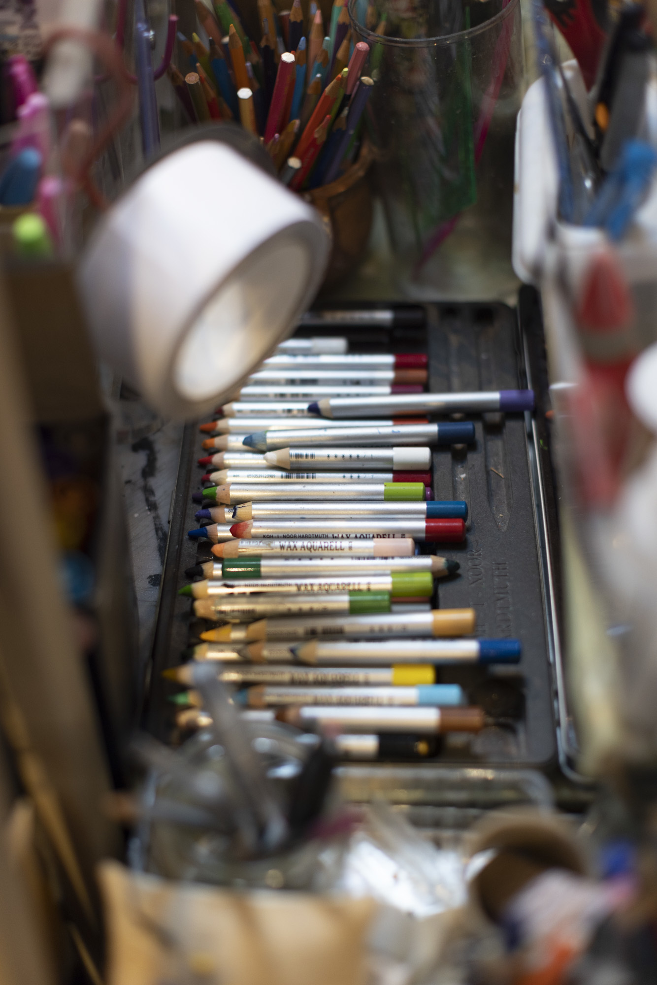 A collection of coloured white pens in a drawer.
