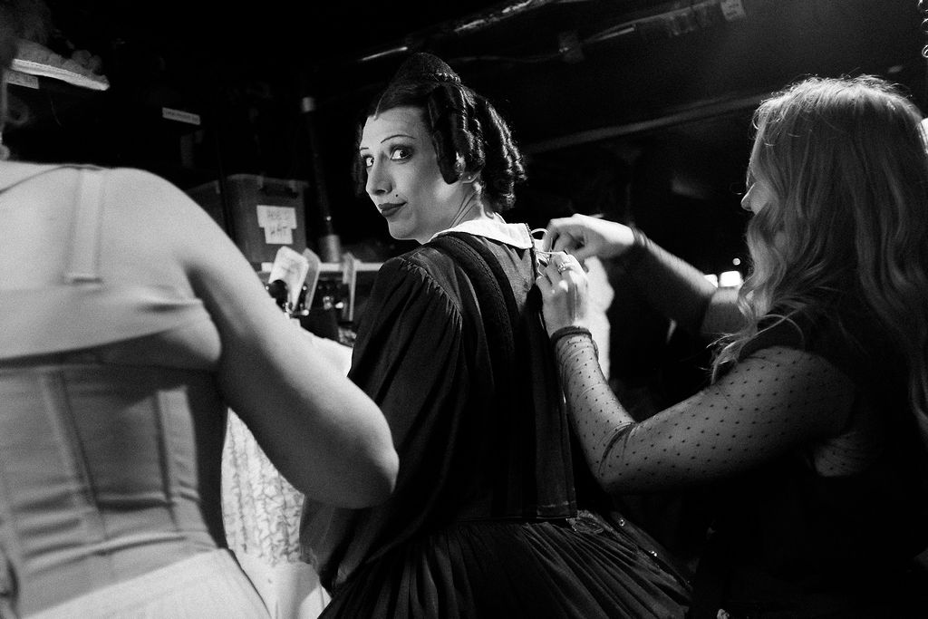 Wardrobe Assistant P Spear makes an adjustment to M A Park's dress; they are in costume as Mary Todd Lincoln, looking towards the camera.