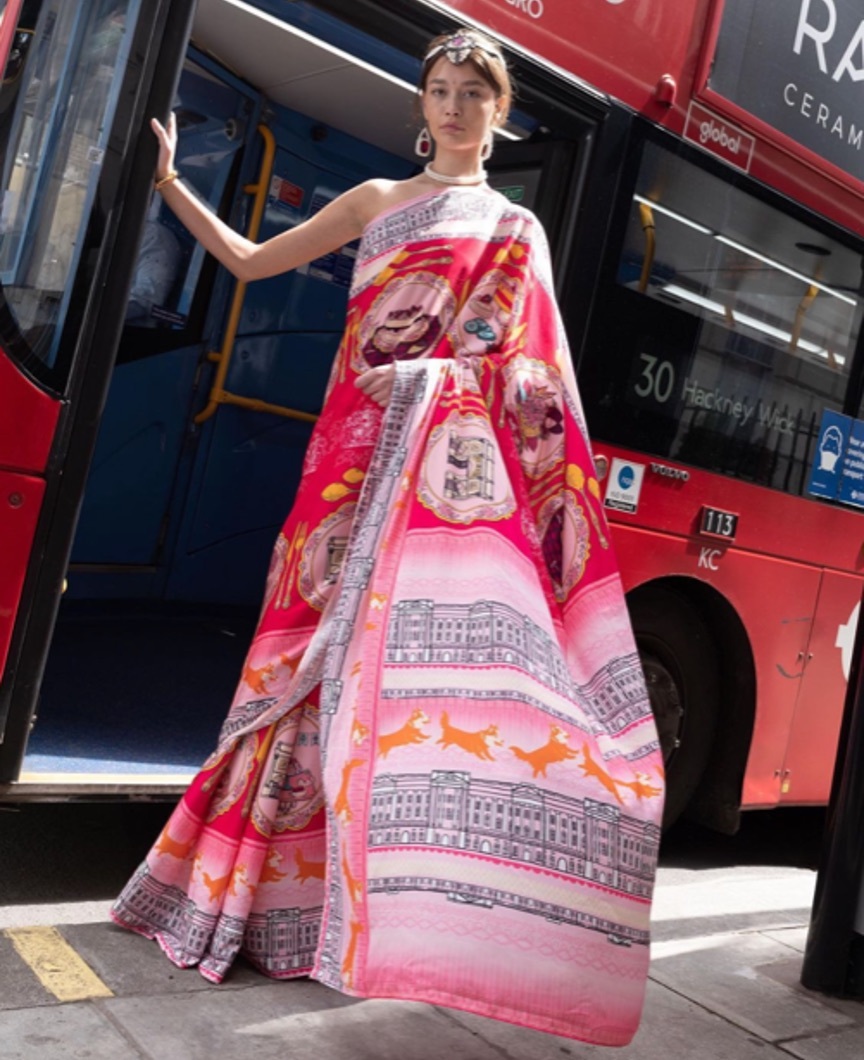 A model wearing a Sari outside of a bus