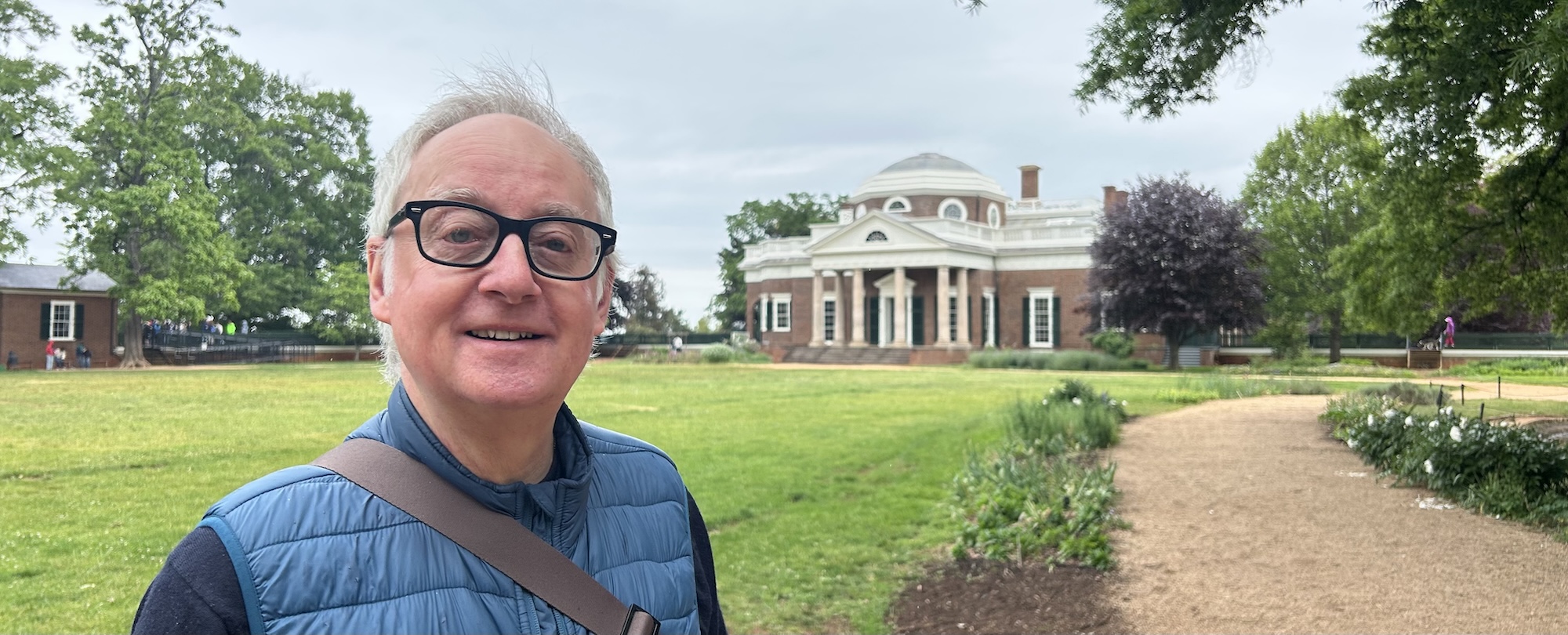 Headshot of P Cook with a stately building in the background.