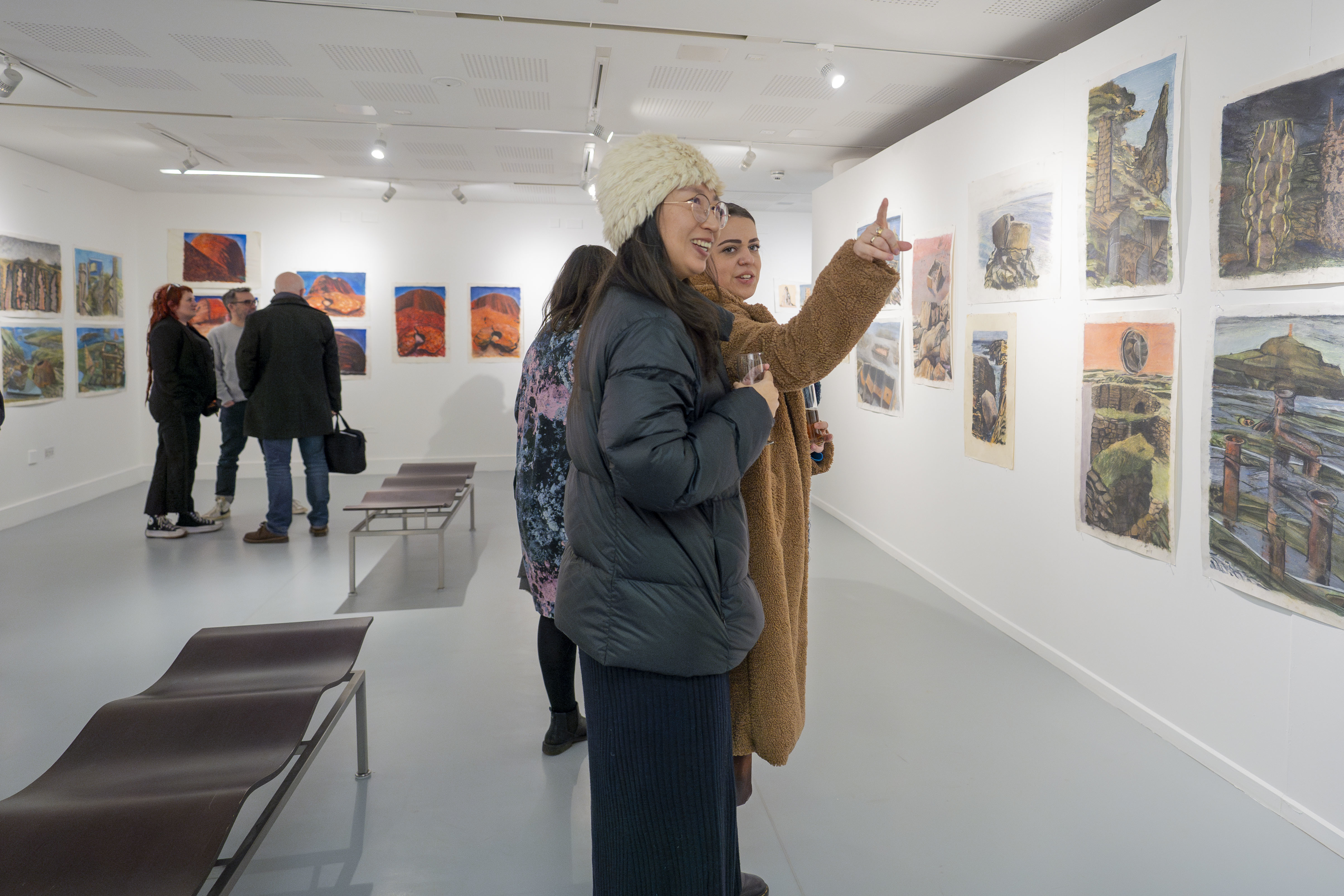 People looking at artworks on display at TheGallery, AUB as part of the Purbeck, Penwith and Purnululu exhibition.