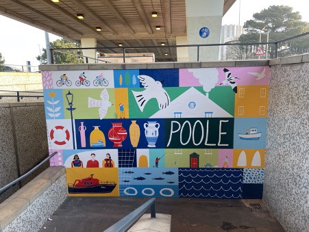 Colourful mural on a wall showing birds, boats, people cycling, vases and other images. The word 'Poole' also appears.