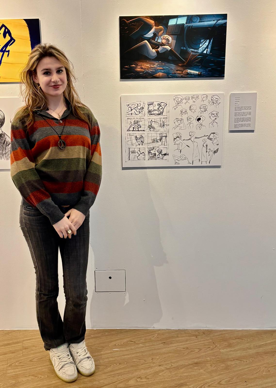 P Vorona standing next to two pieces of concept art displayed at Russell-Cotes Art Gallery & Museum, Bournemouth.