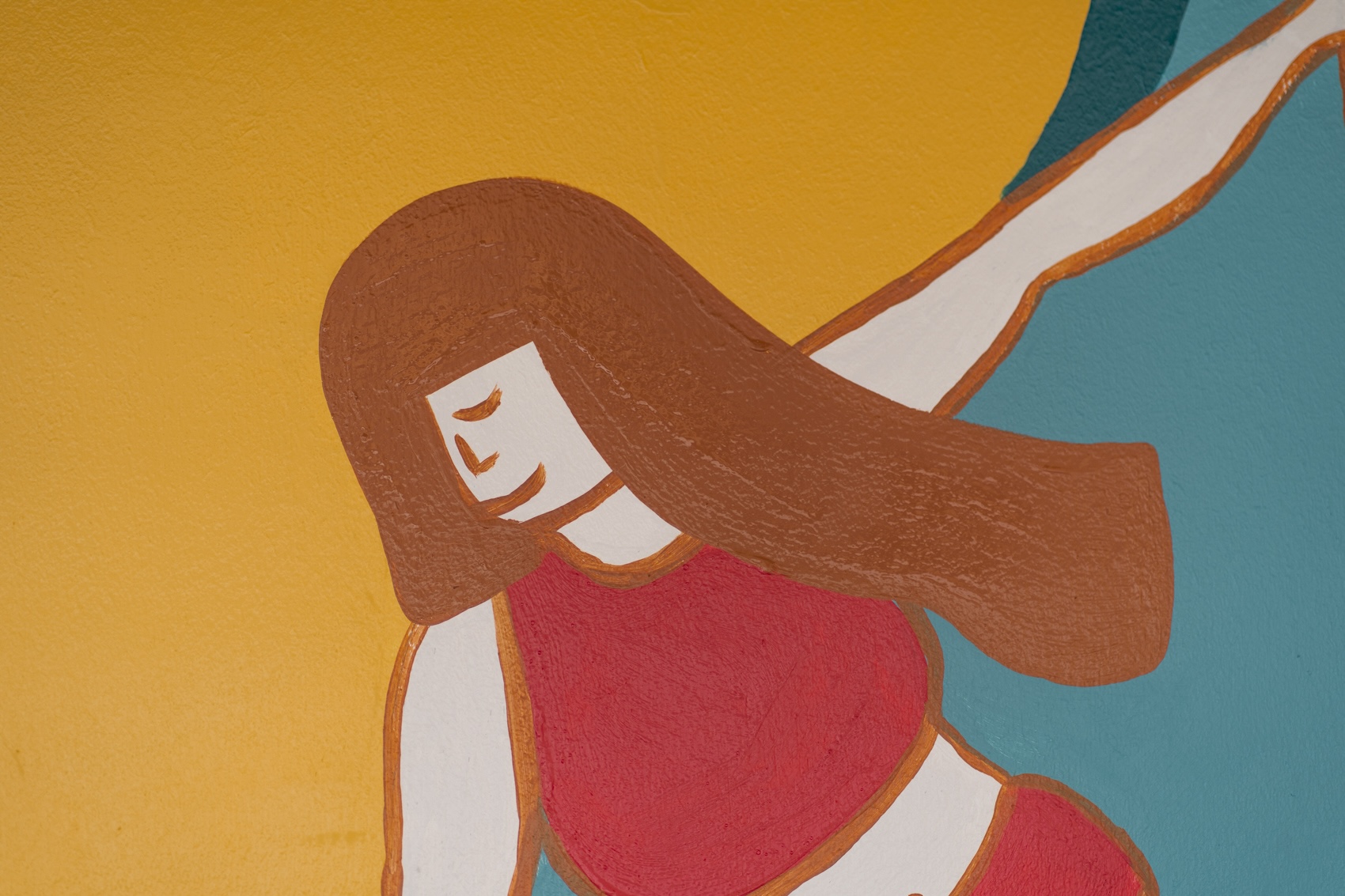 A stylised mural of a woman with long brown hair and a pink top against a yellow and teal background.