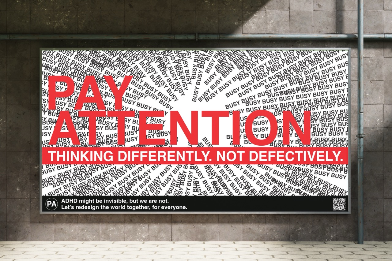 Mock-up billboard with red capitals in the middle: 'Pay attention, thinking differently, not defectively' with lines of the word 'busy' jutting into the middle.