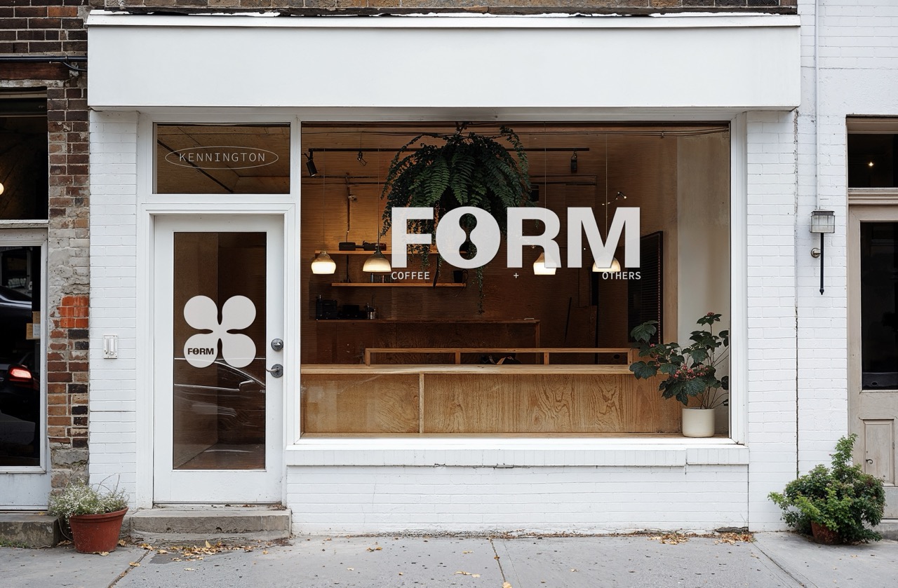 White cafe storefront with white 'Form' typography, warm lights and plants inside.
