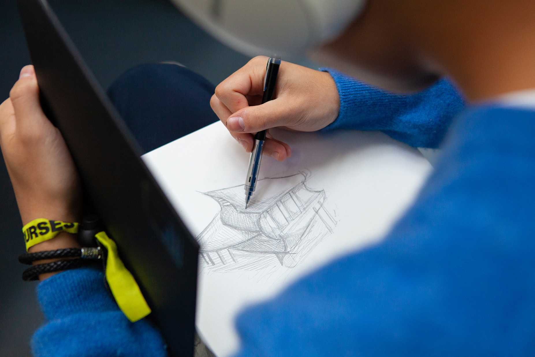 A student is drawing a building in their sketchbook
