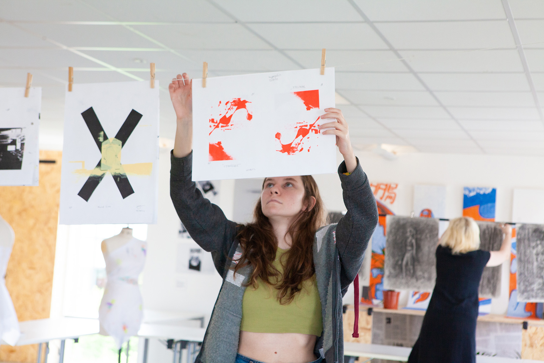 A student is hanging a screen print up to dry