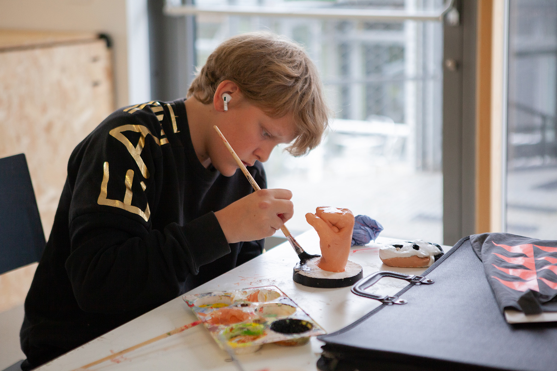 A student is painting a sculpture of a hand