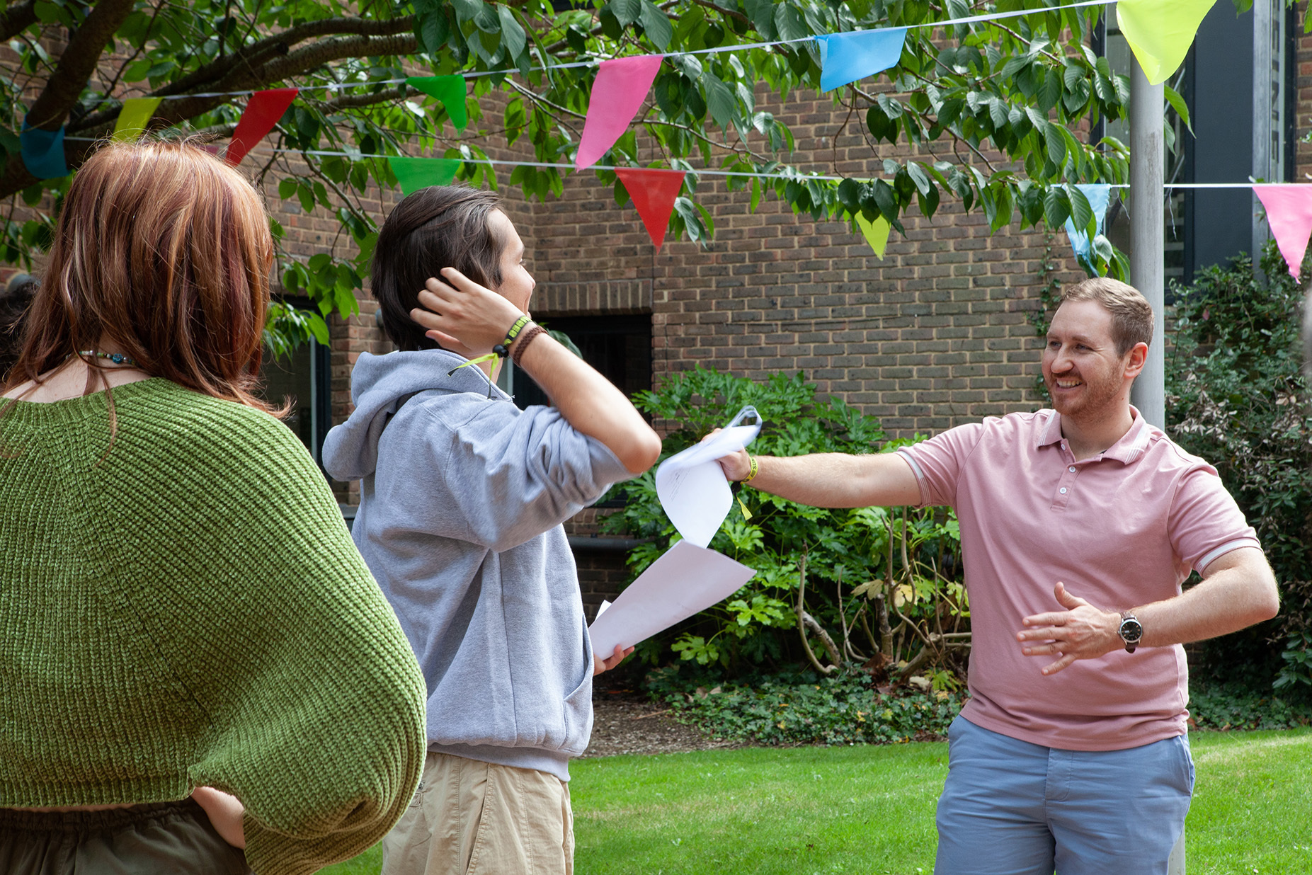 Three actors are rehearsing holding their scripts