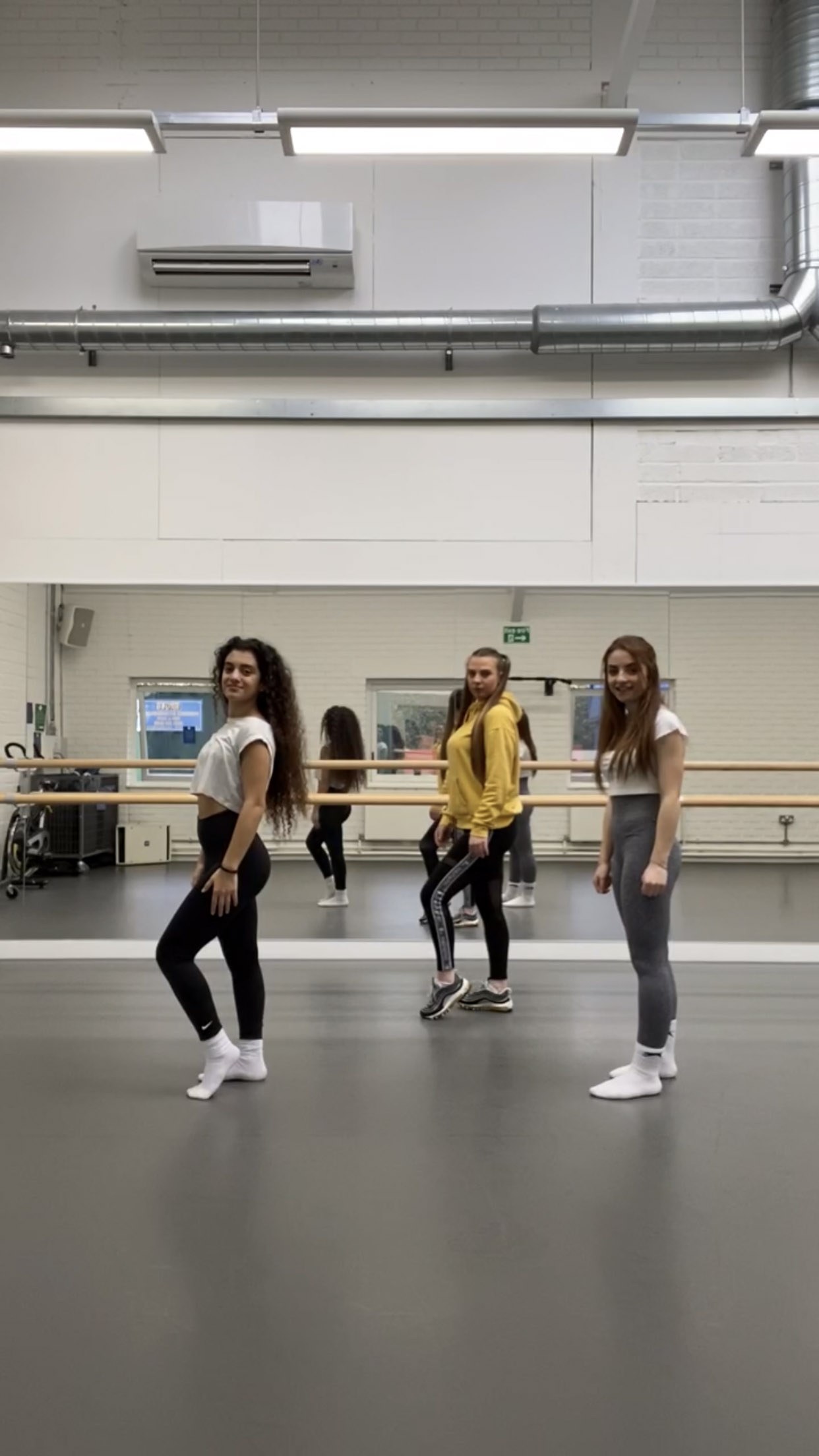 Three BA (Hons) Dance students rehearsing a routine in a dance studio.
