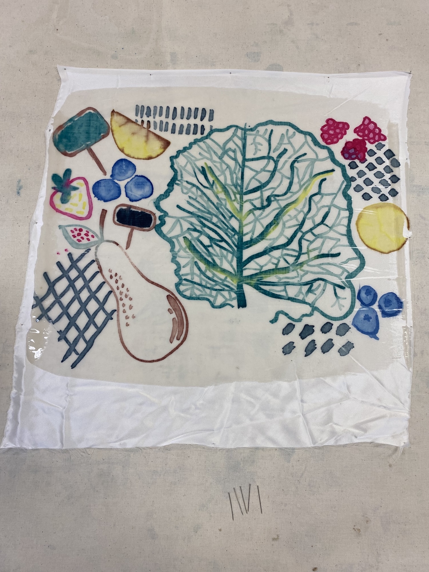 Colourful print on white paper featuring green tree, blue circles, yellow shapes, crosshatch patterns, and colourful geometric forms.