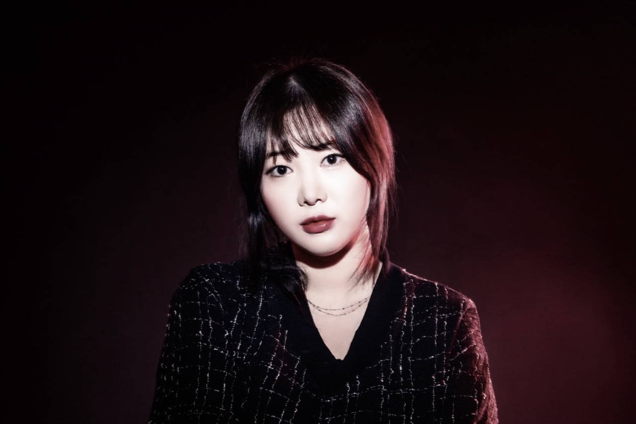 Editorial shot of Eunbi Go in dark red lighting.