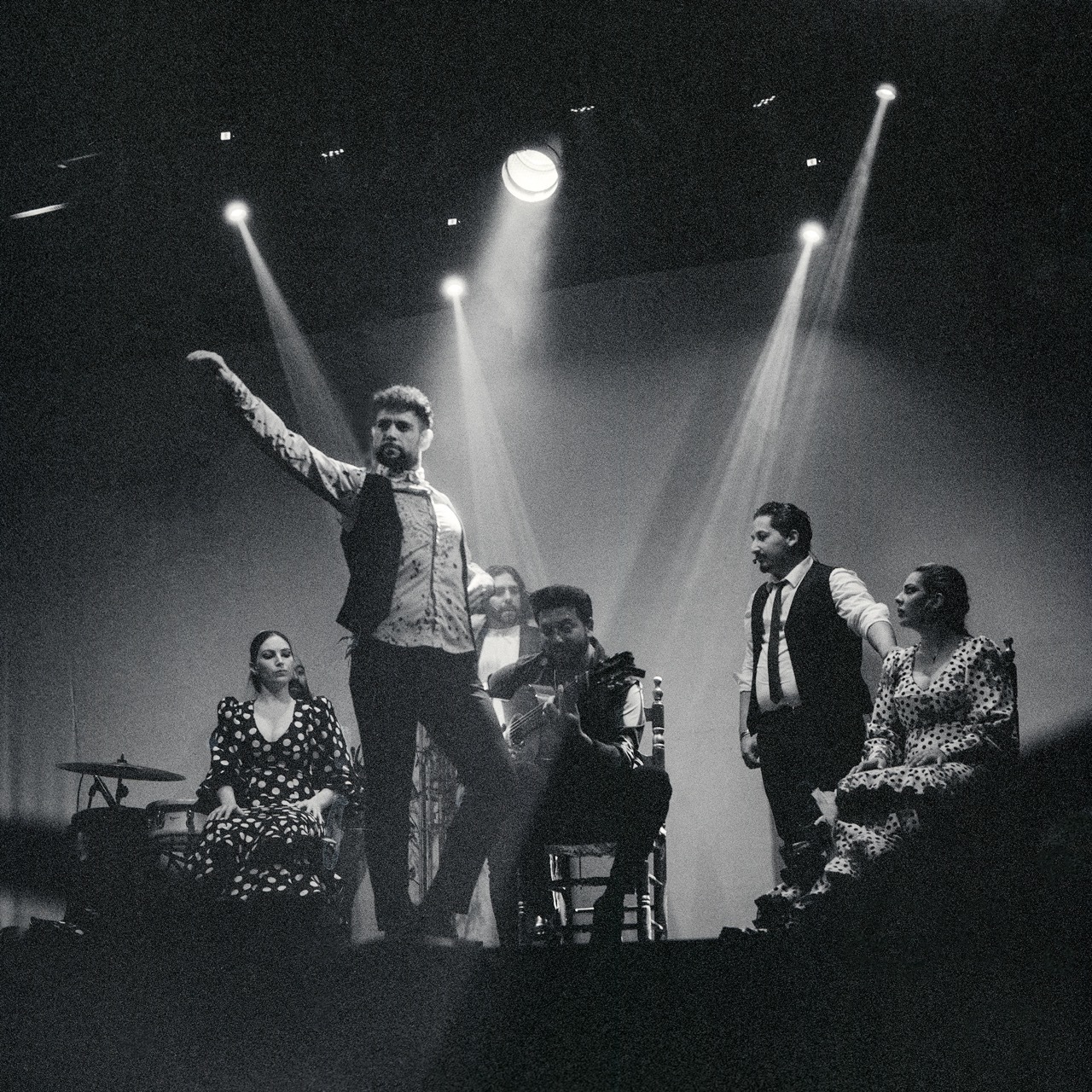 B&W photo of a flamenco band under stage lights.