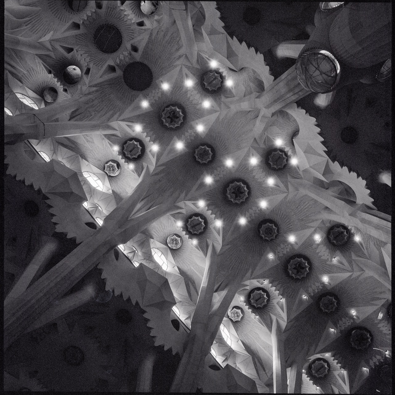 B&W photo of the Barcelona Sagrada ceiling, appearing abstract and kaleidoscopic.