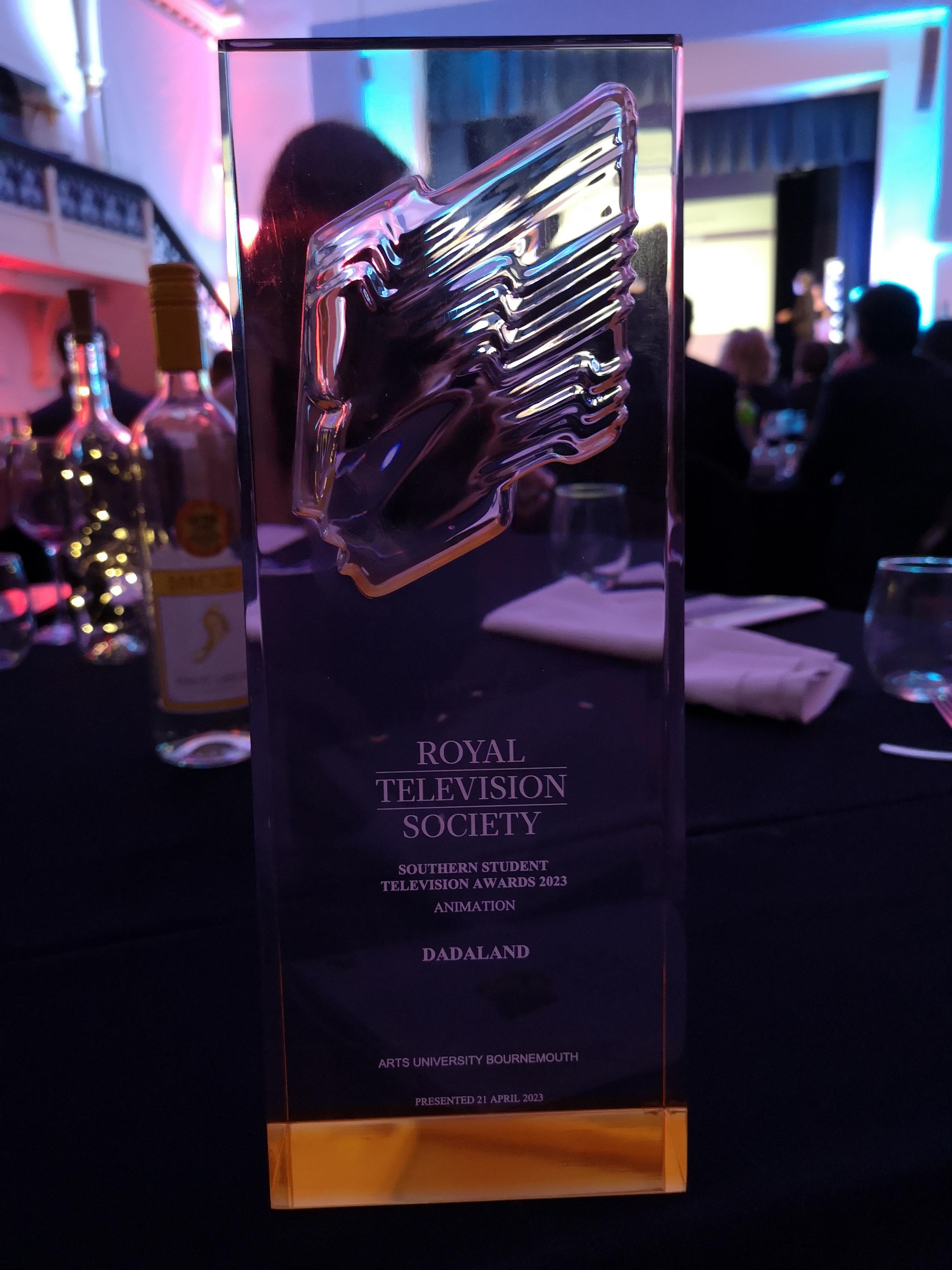 A glass trophy resting on a table with the words 'Royal Television Society' printed on it.