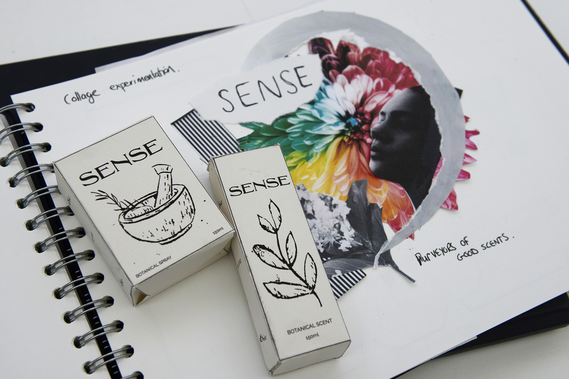 Sketchbook page showing collage experimentation for 'Sense' botanical scent. Two pieces of packaging for 'Sense' lie on top of the page.