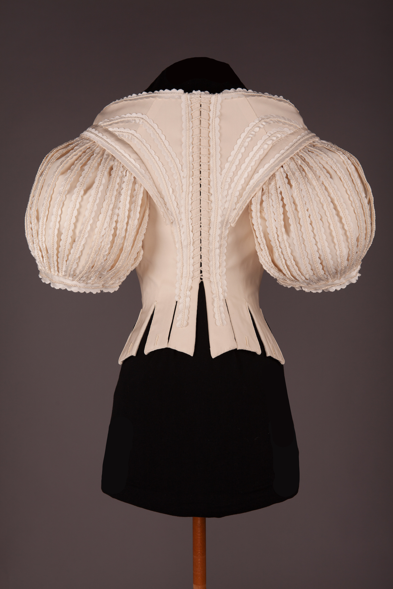 The back of a 1660s bodice, displayed on a mannequin.
