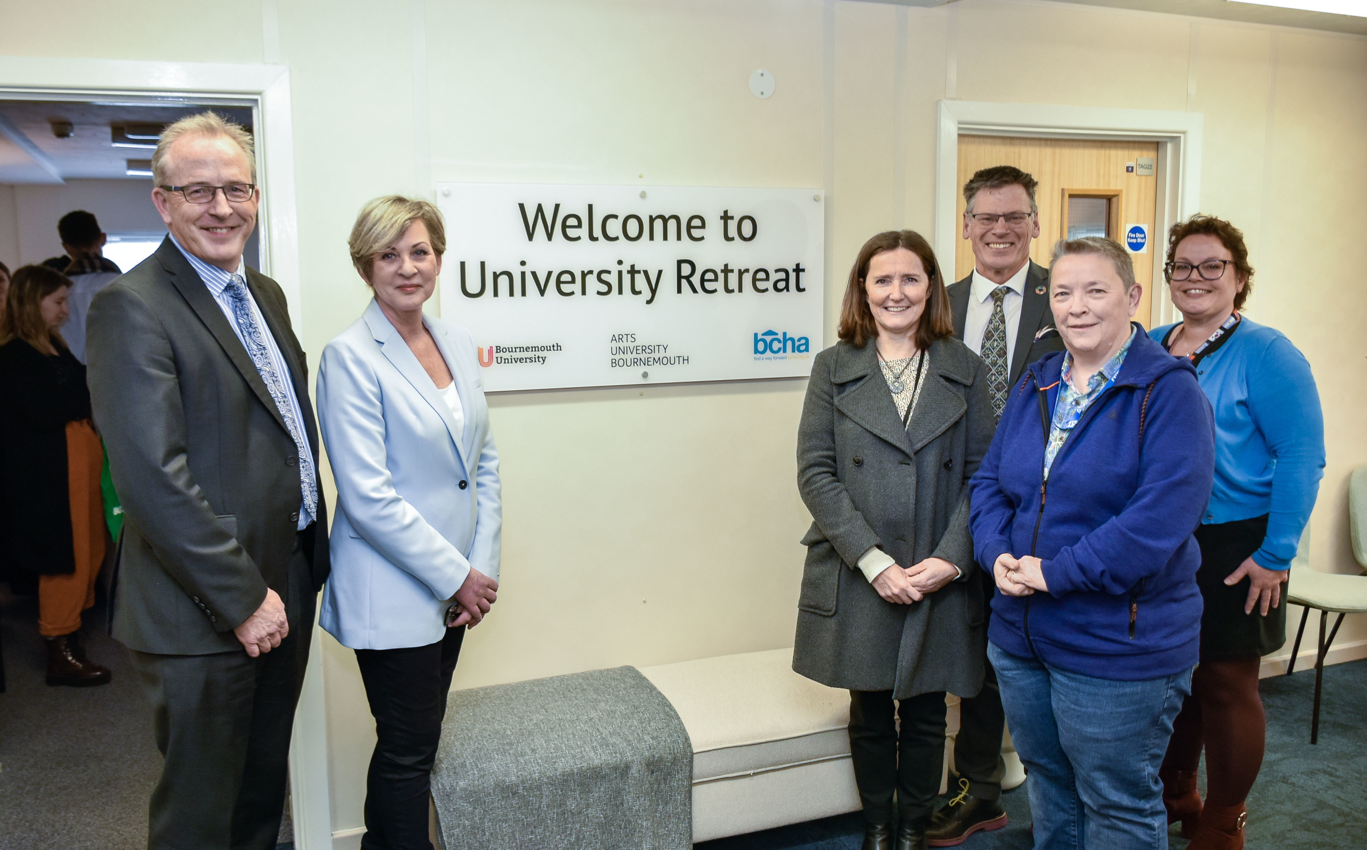 AUB and BU staff open University Retreat on University Mental Health Day. Six people pose for a photo in a waiting room, standing either side of a sign that reads 'Welcome to University Retreat'.