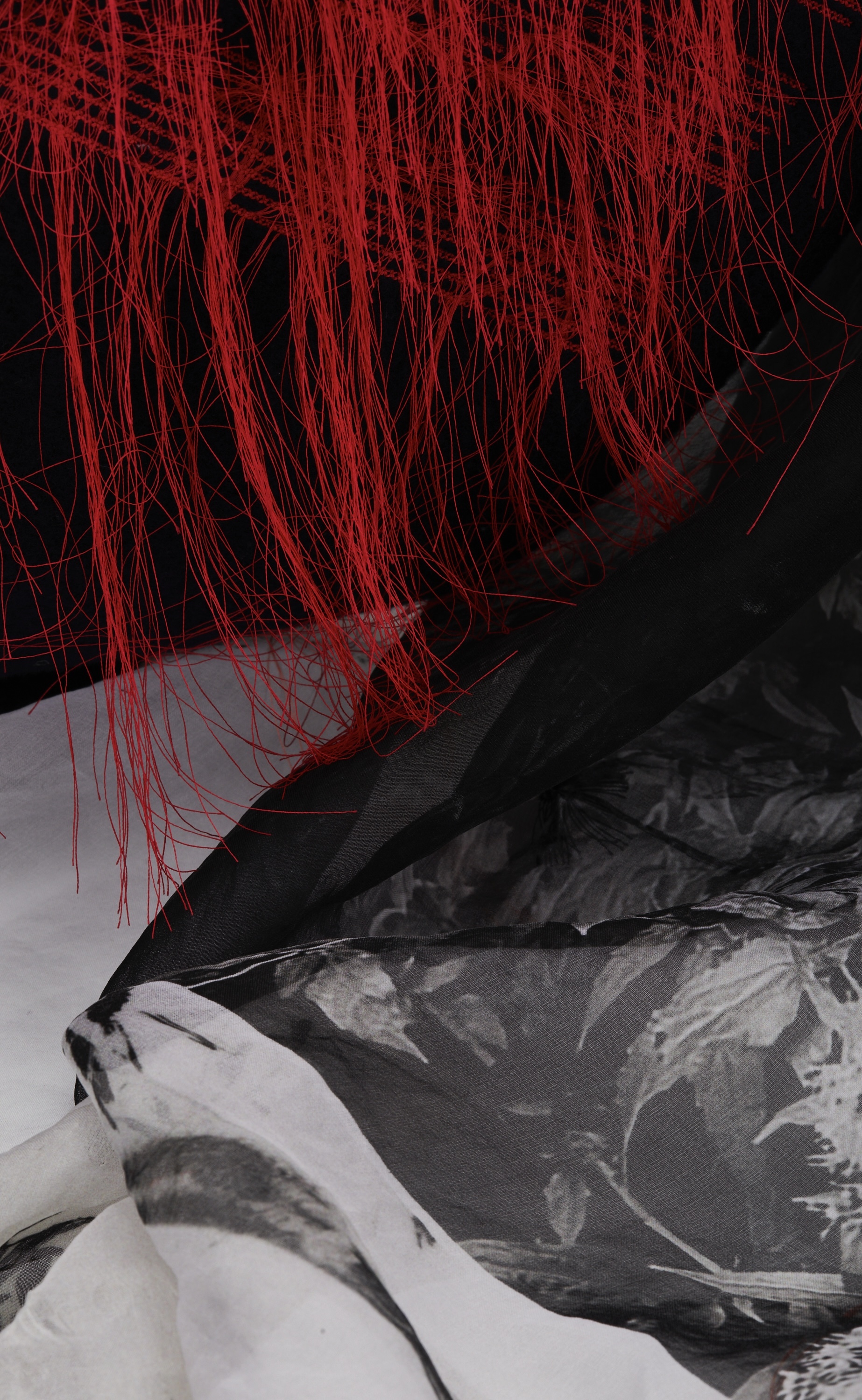 Black and grey fabric with red tassels handing above.