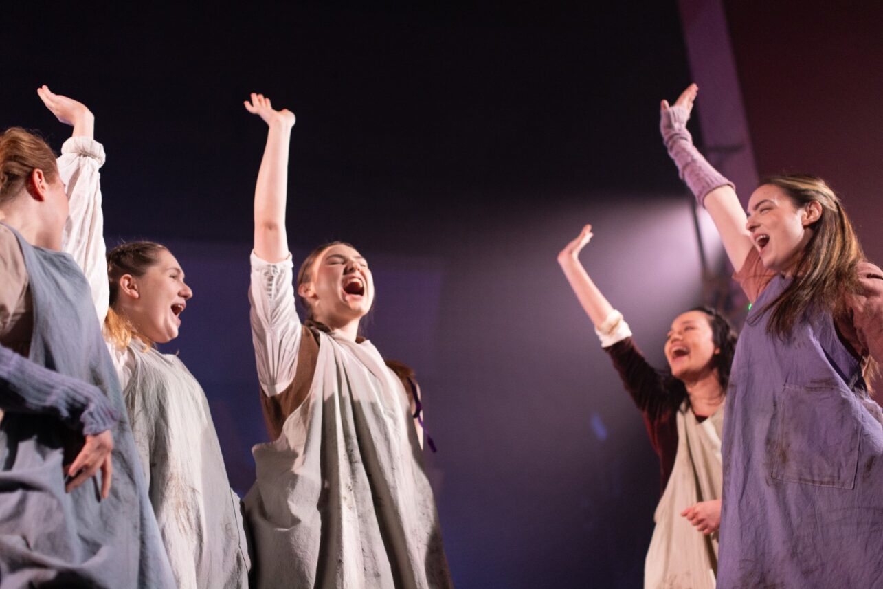 The Ballad of Maria Marten – AUB actors on stage in costume shouting with their hands in the air.