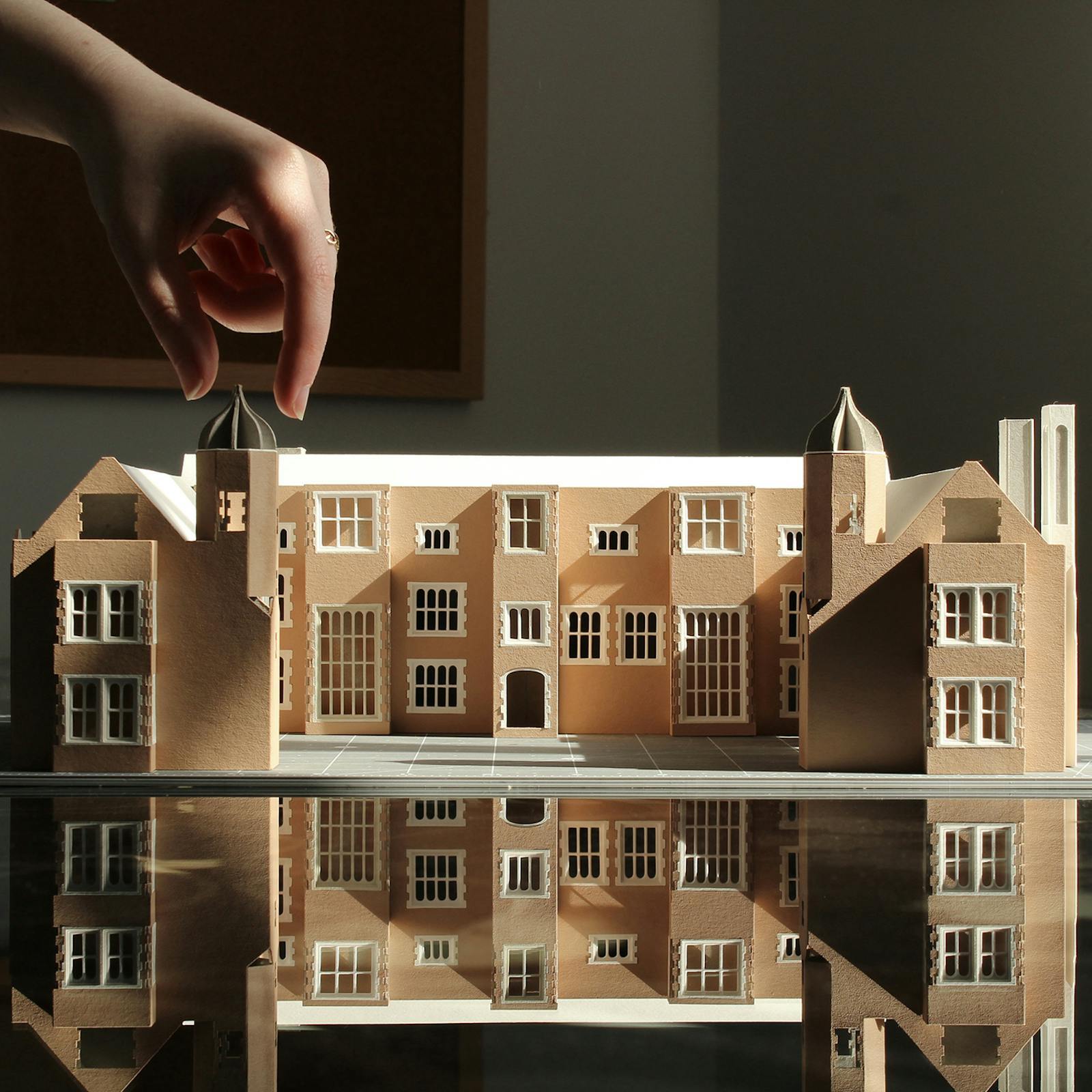 Close-up of a model of a large stately building, on a reflective surface.
