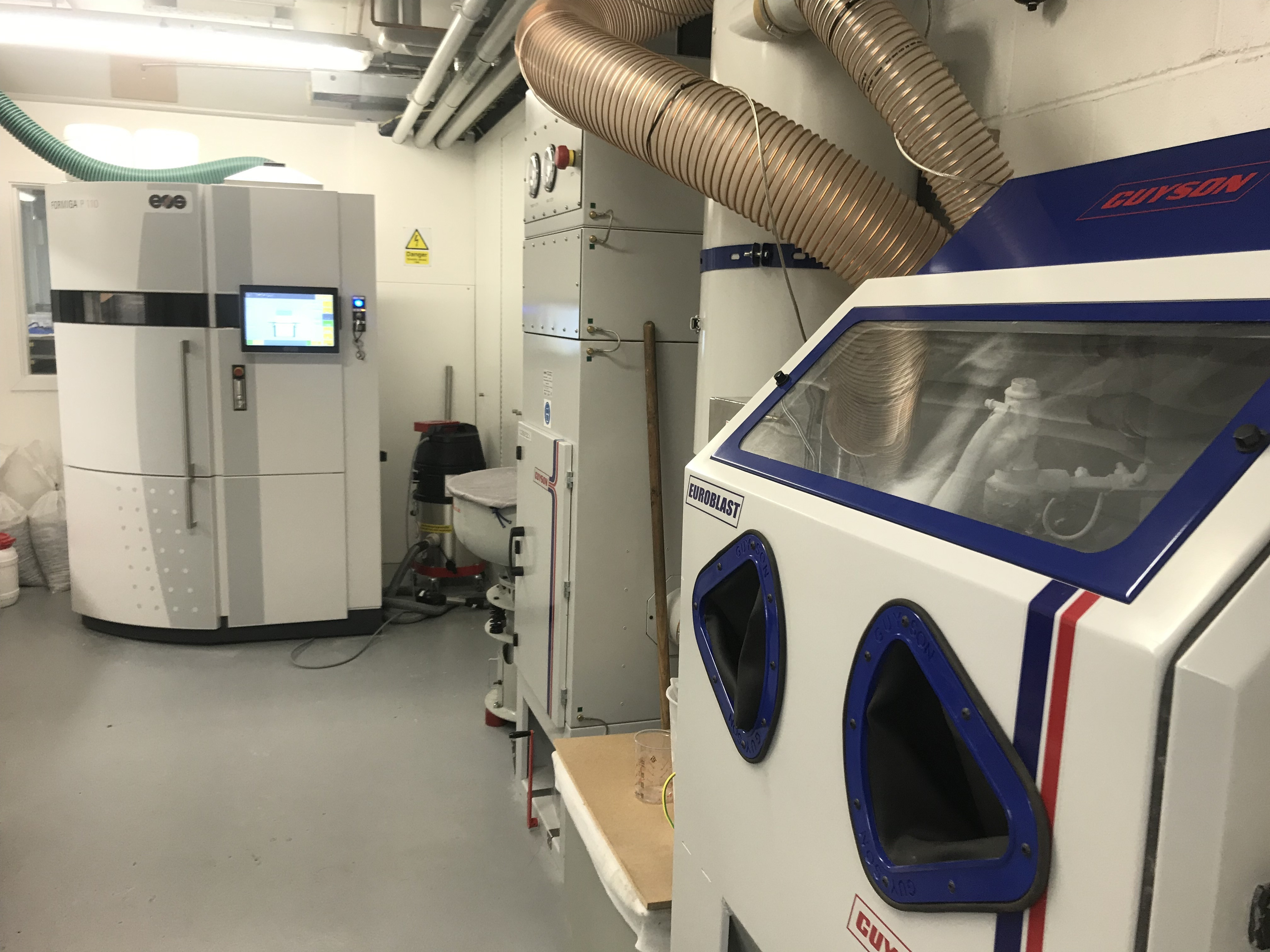 A 3D printer in a lab-style room.