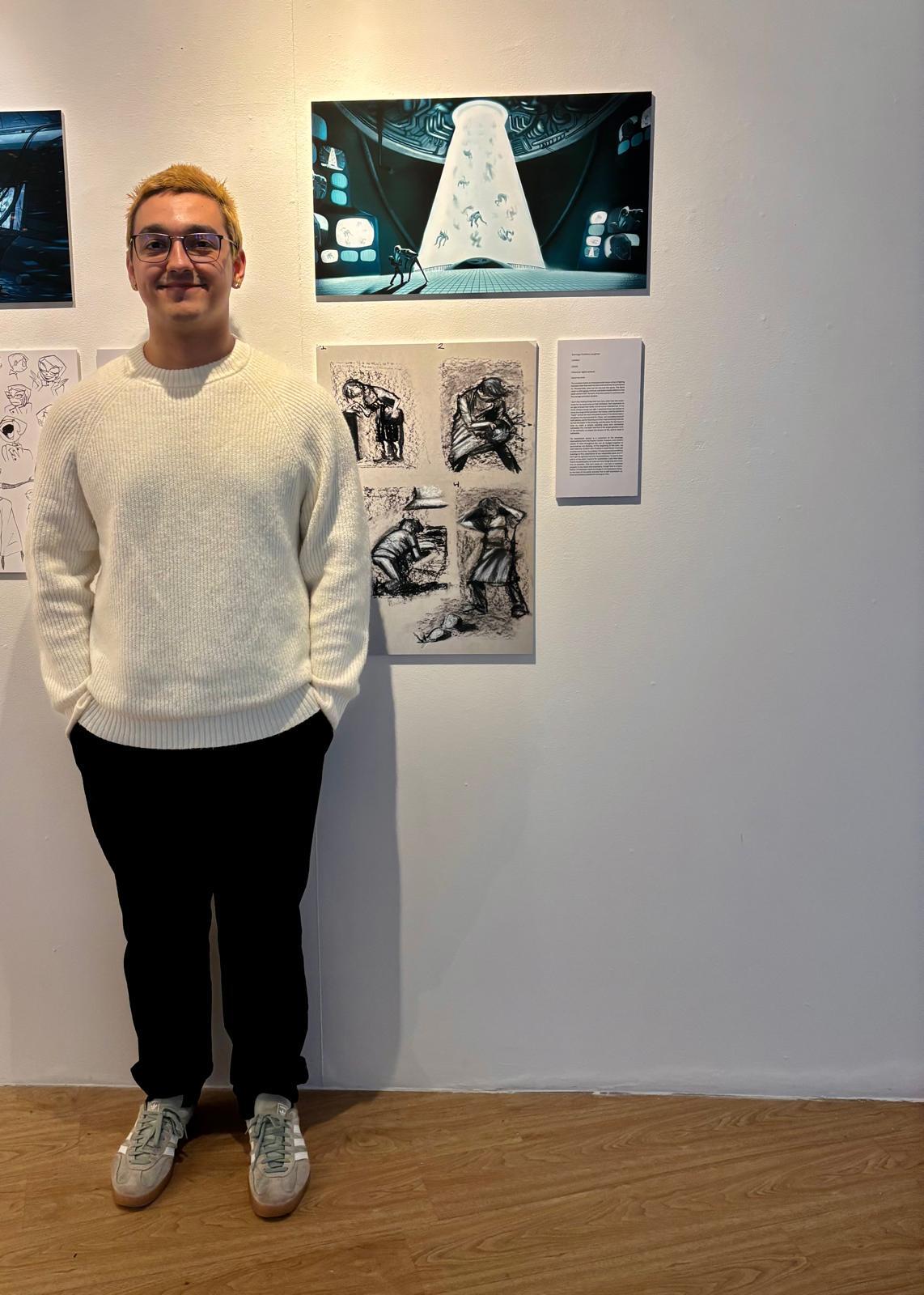 S C Loughran standing next to two pieces of concept art displayed at Russell-Cotes Art Gallery & Museum, Bournemouth.