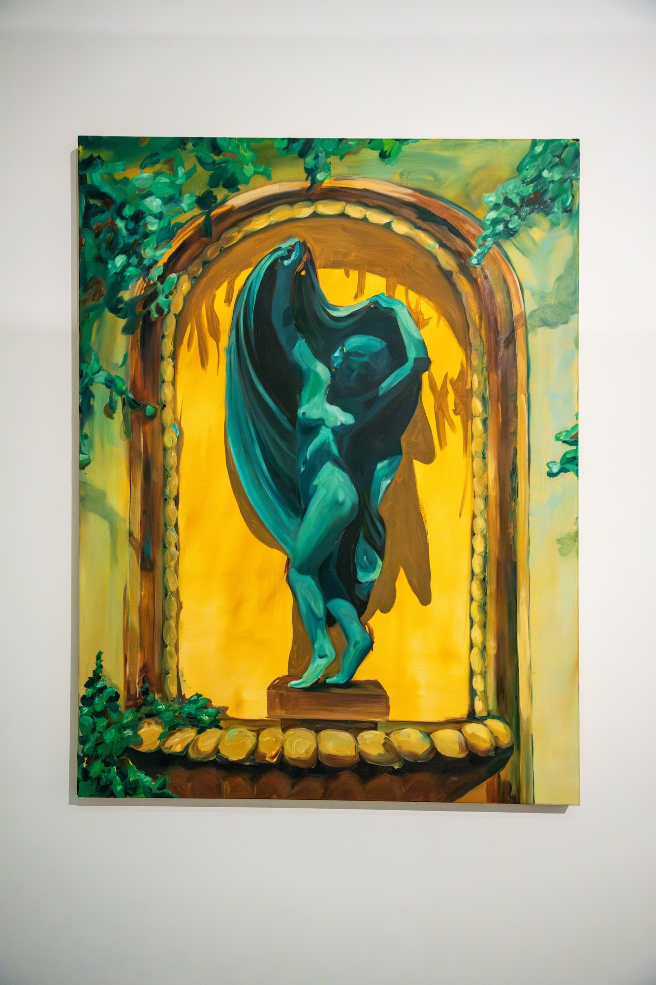 Painting of a statue of a nude woman draping a sheet or cape over her head, surrounded by a yellow-coloured arch and greenery.