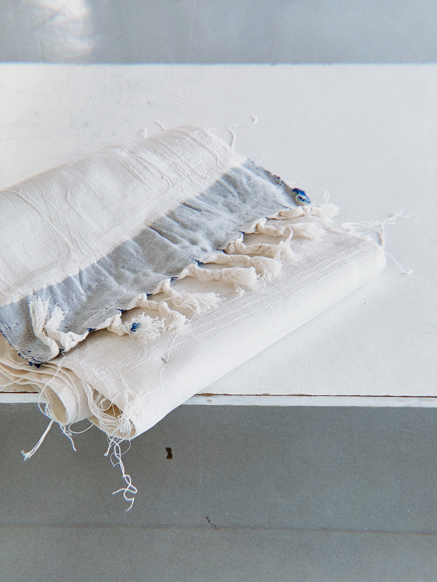 White, blue and cream tasseled fabric.