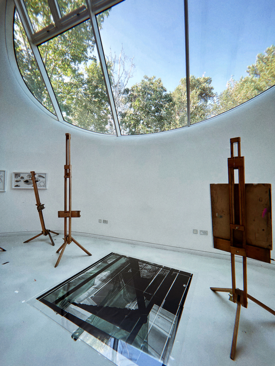 Mirrored art on the floor in the AUB Drawing Studio next to wooden easels.