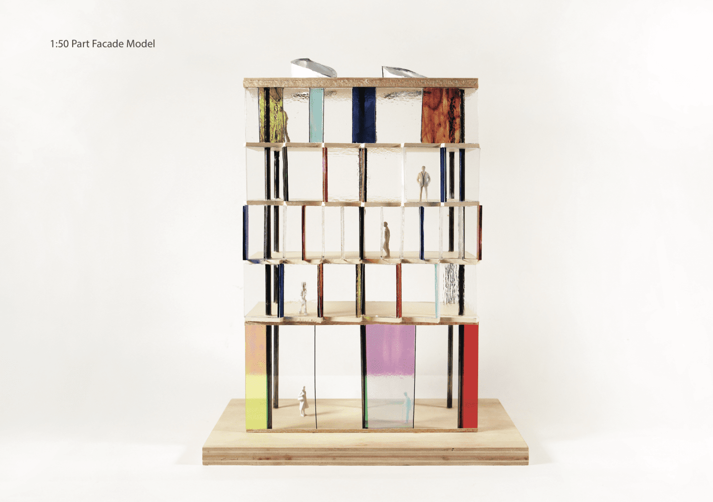Model of a five-storey building on a wooden base with clay miniature figures on each floor.