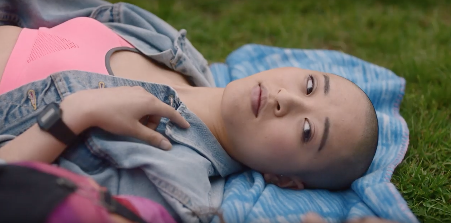 Lady laying on the grass looking at someone off-camera