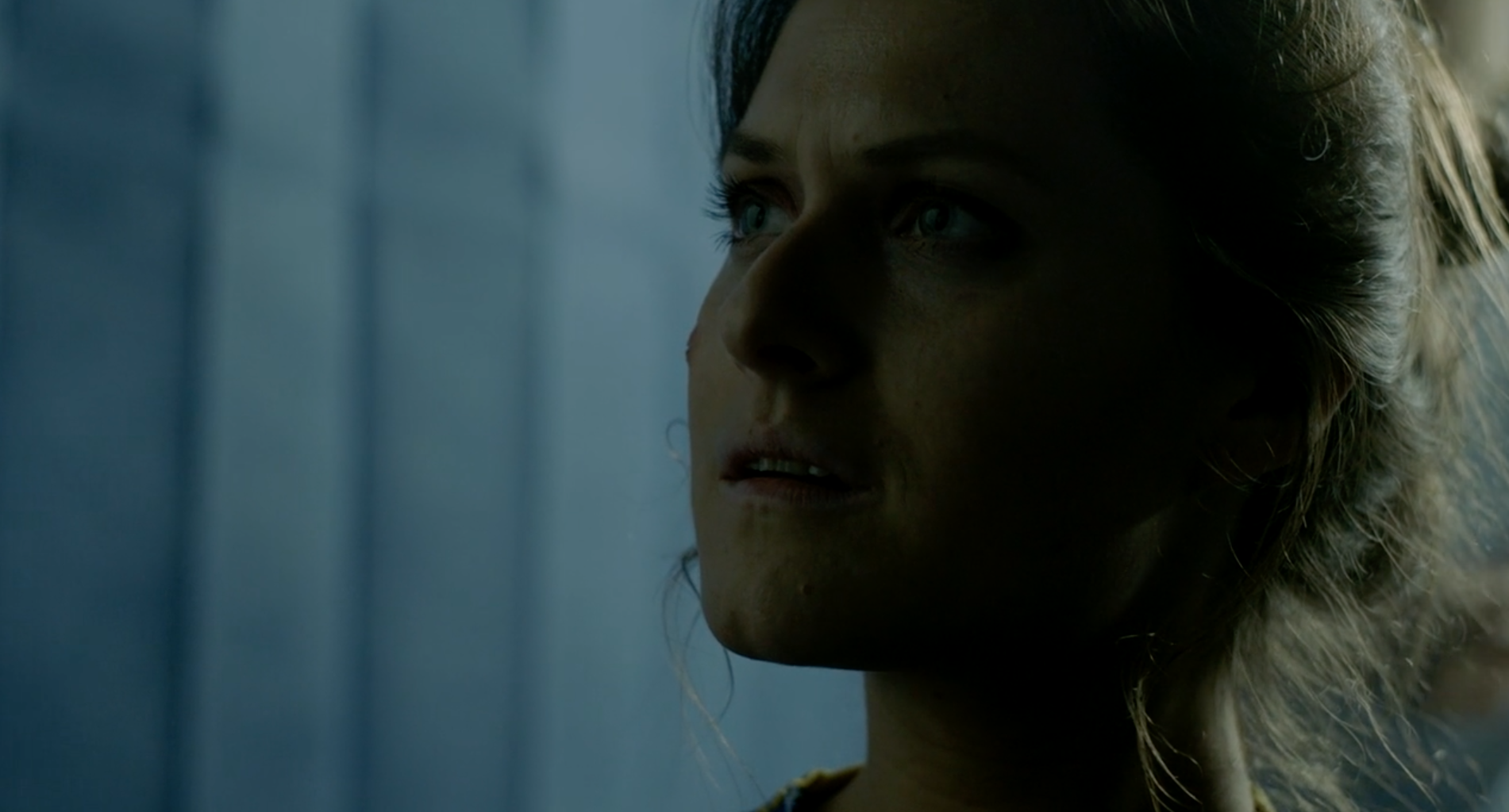 Film still of a close-up of a woman's face. She has a serious expression.
