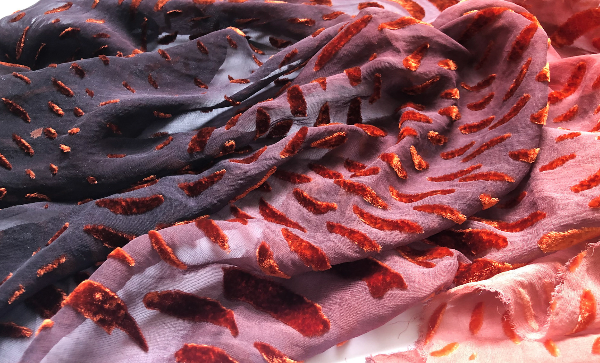Close-up of a piece of fabric patterned with several velvety tufts.