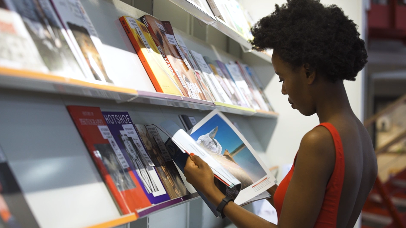 Student looking through a magazine at the Library