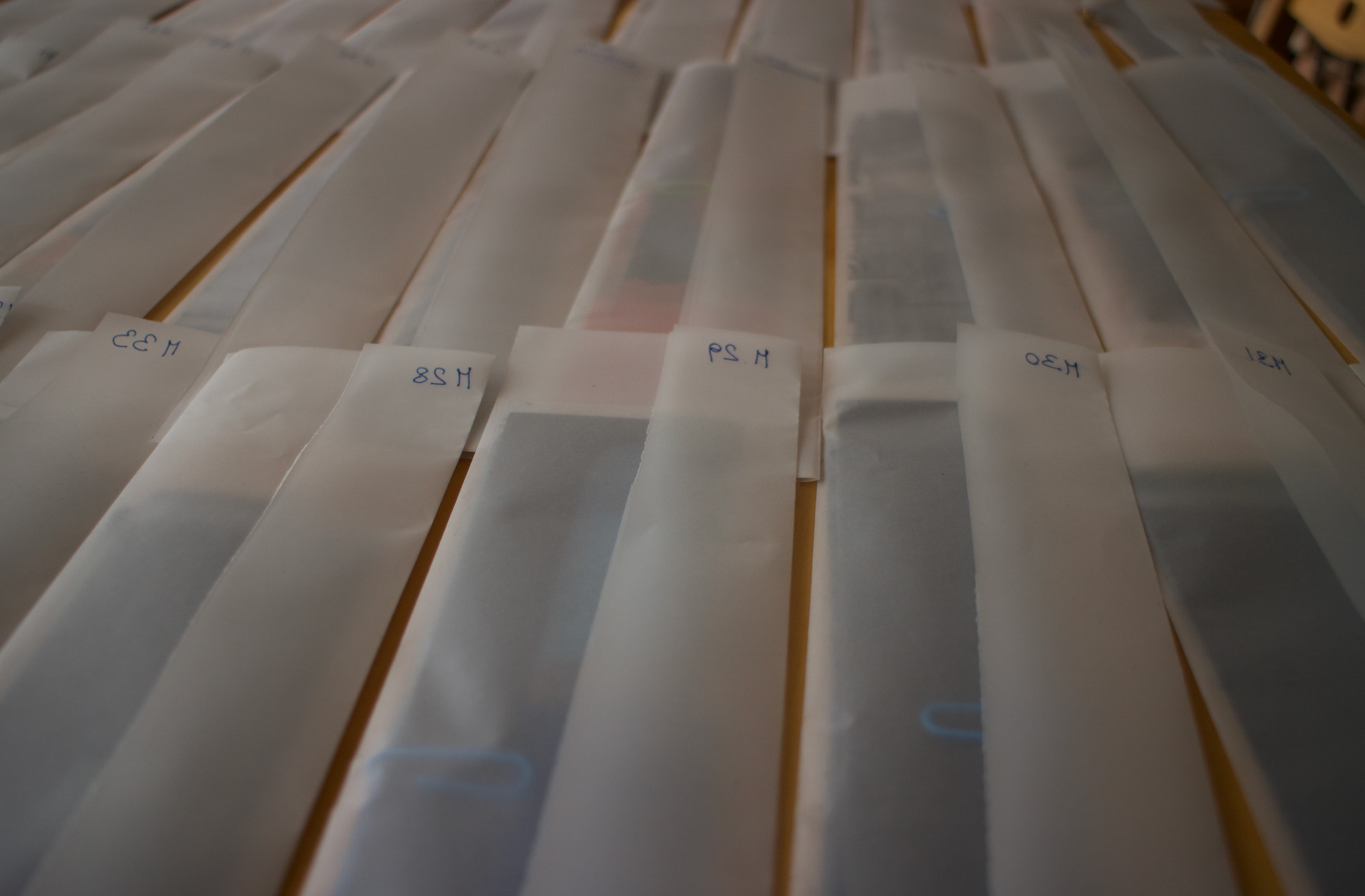 A selection of documents wrapped in paper and numbered in their top-right corners lie arranged on a table.