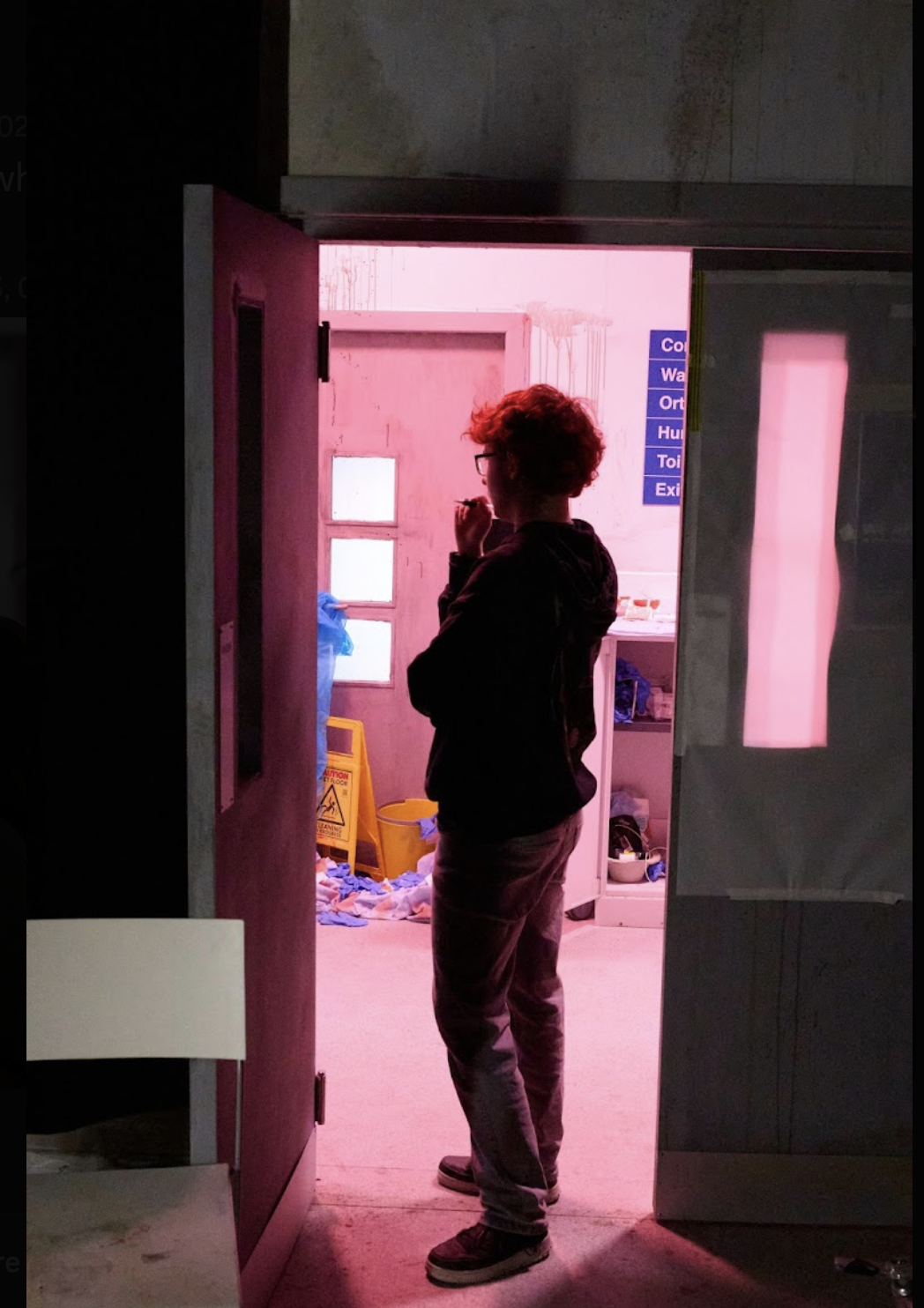 BA (Hons) Film Production student D Clarke standing in a doorway in a hospital ward, on the set of a graduation film.