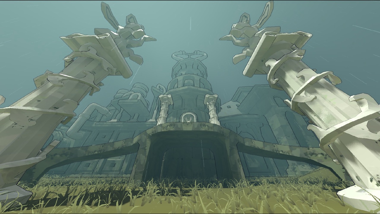 A large stone tower with two massive carved pillars in front, seen from a low angle with grass in the foreground and a pale blue sky behind.