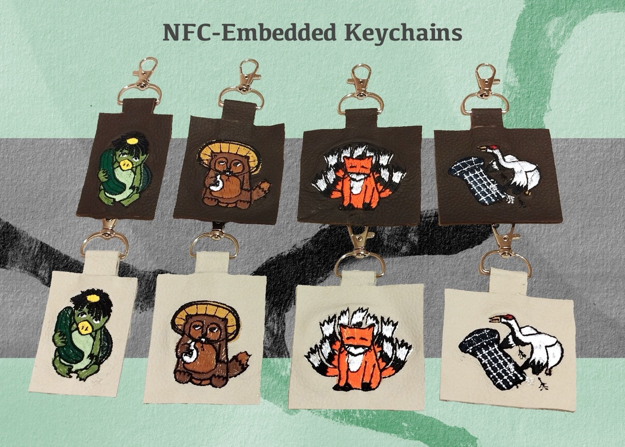 Eight NFC-embedded leather keychains with machine embroidery of different Japanese folktales on yōkai. From left to right: Kappa, Tanuki, Kitsune, Tsuru no Ongaeshi.