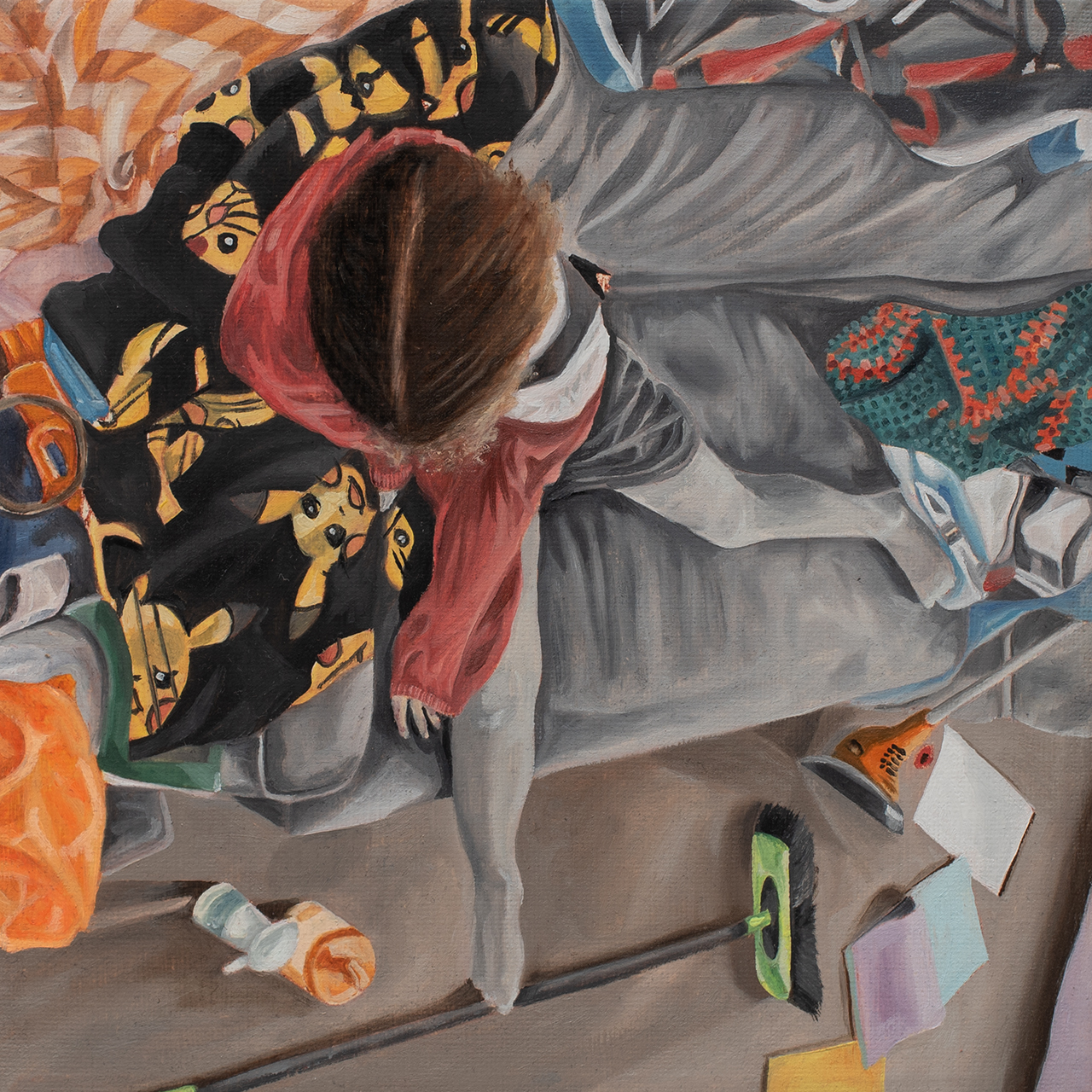 Figure in grey hoodie and red scarf crouched amongst scattered papers, with black fabric featuring yellow cartoon characters visible.