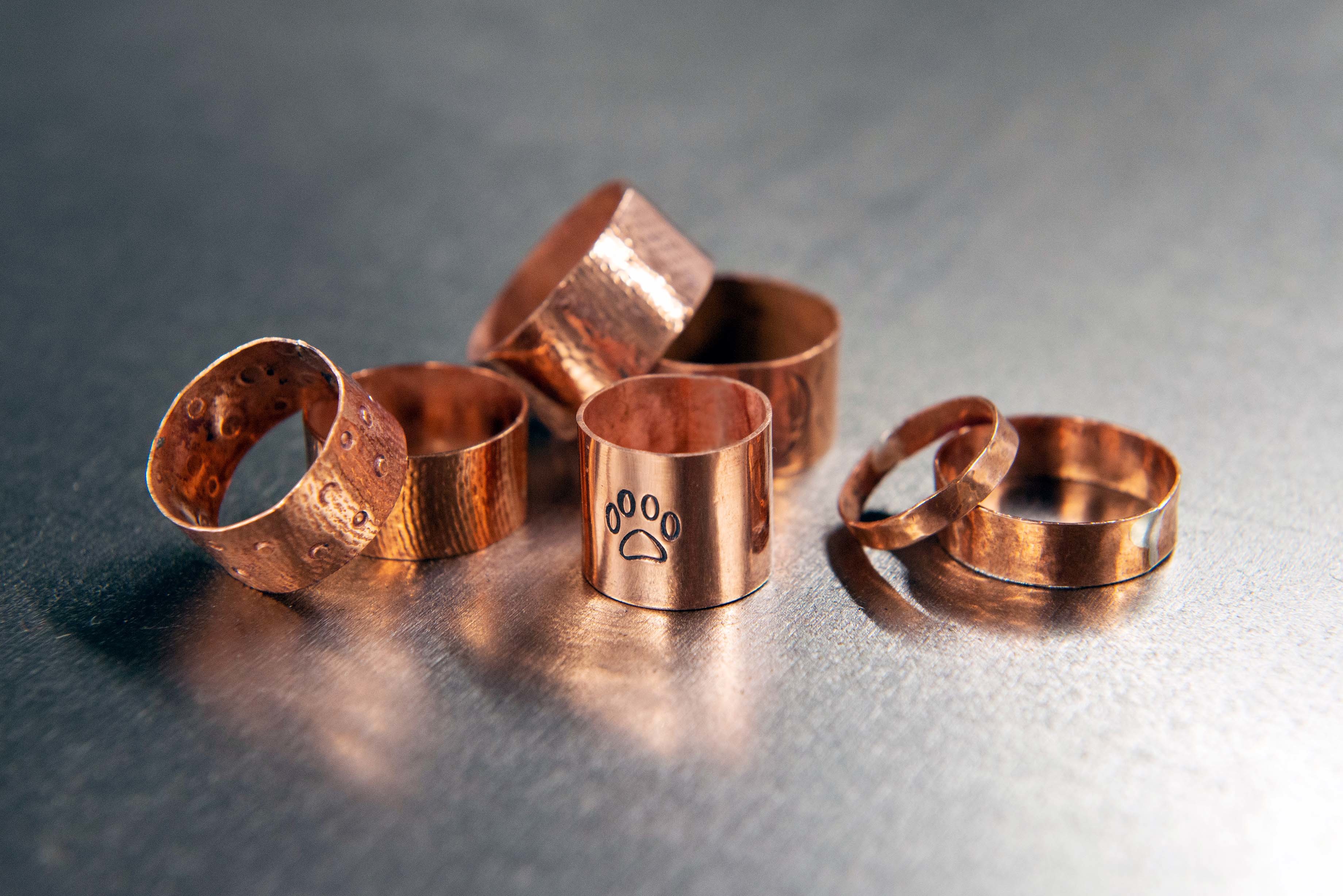 A pile of copper rings on a metal surface.