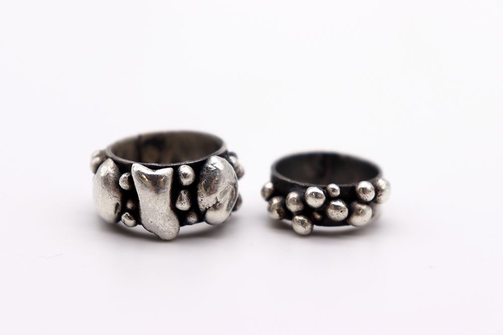 Two rings encrusted with silver pieces of various sizes.
